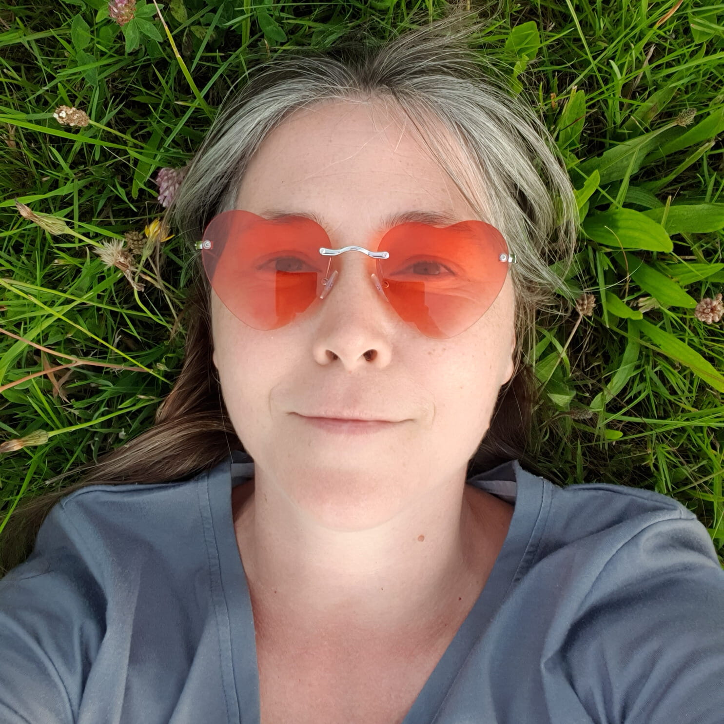 Selfie von Elke Raab während sie auf einer Wiese liegt